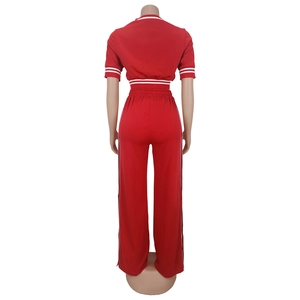 Vista posteriore della tuta rossa due pezzi con crop top e strisce bianche laterali