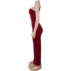 Détail d'une robe maxi moulante bordeaux avec d'élégants strass décoratifs sur le côté de la robe
