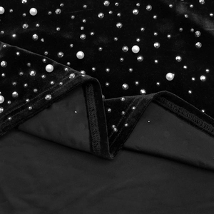 Détail macro du tissu en velours noir avec perles incrustées et strass étincelants