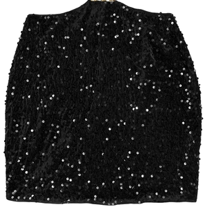 Détail de la texture étincelante des paillettes noires sur cette mini robe de soirée en velours