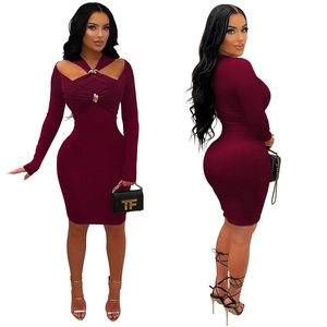 Détails de l'encolure évidée avec boucles dorées sur la robe moulante de couleur bordeaux