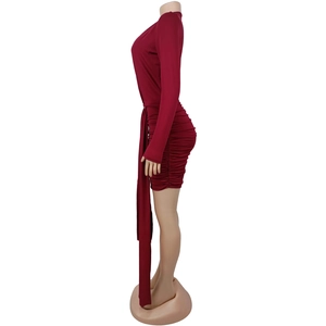 Close-up of side ruching and long decorative sash on dark red mini bodycon dress