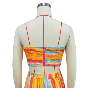 Detail view of the metallic back zipper on a colorful striped pleated two-piece outfit