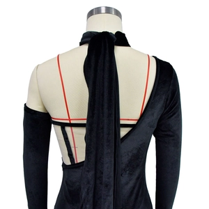 Détail d'une robe dos nu en velours noir montrant le col licou et la texture douce