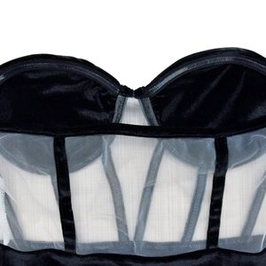 Détail du décolleté en velours noir et corset en mesh transparent avec baleines