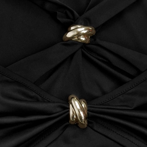 Détail d'une robe noire à épaules dénudées avec des boucles en métal doré élégantes