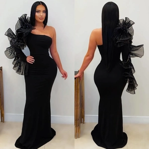 Detail of elegant one-shoulder black mermaid dress with ruffled organza floral sleeve