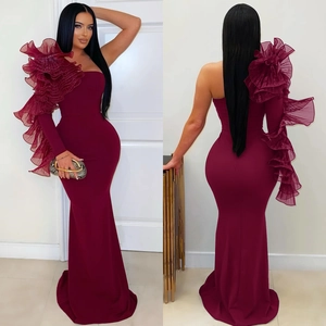 Detail of burgundy one-shoulder dress with layered tulle ruffles and mermaid hem