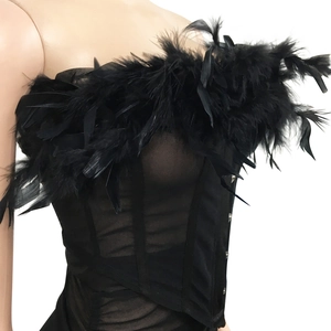 Dettaglio del corsetto in mesh nero con bordo in piume e chiusura laterale a gancetti