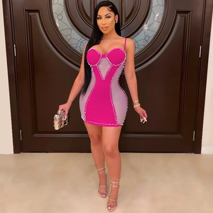 Close-up of pink bodycon dress with pearl trim and sheer mesh side panel detail
