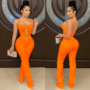 Detail of neon orange two-piece set featuring front zipper corset and mesh panel leggings