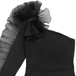 Detail of elegant black dress showing a single shoulder and layered mesh ruffle sleeve