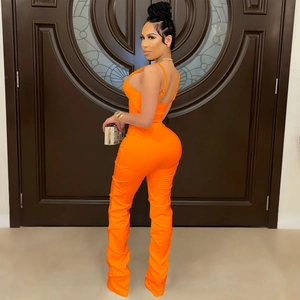 Detail of vibrant orange two-piece set featuring stacked legs and a crop camisole top