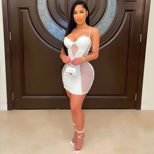 Close-up of white mesh mini dress with elegant pearl trim and sleek bodycon silhouette