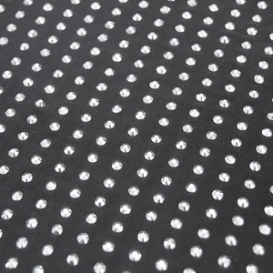 Detailaufnahme von schwarzem Netzstoff mit dichtem Besatz aus glitzernden Strasssteinen