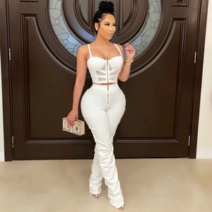 Detail view of white two-piece set featuring mesh panel corset top and high-waist pants