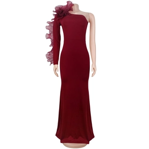 Detail of the elegant wine red one-shoulder dress with sculptural ruffle sleeve and mermaid cut