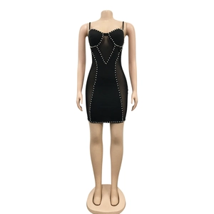 Detail of black mini dress with pearl accents, heart neckline and mesh insert