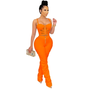 Detail of orange two-piece set featuring front metal zipper on corset top and flared pants
