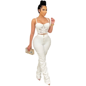 Detail view of white bustier top with zipper and high-waist pants with sheer mesh