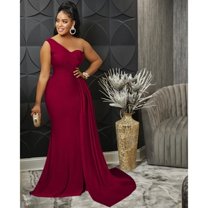 Close-up of elegant burgundy one-shoulder evening gown with ruched waist and fishtail hem