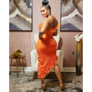 Detail of vibrant orange one-shoulder bodycon dress with ostrich feather trim and slit