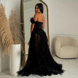 Close-up of elegant black mesh evening gown featuring feather trim and layered tulle details