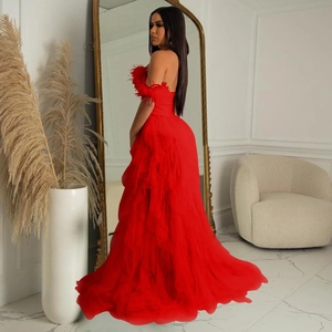 Detail of red strapless evening gown featuring layered tulle skirt and feather trim
