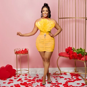 Detail of yellow bodycon dress with ostrich feather trim and pleated fabric texture