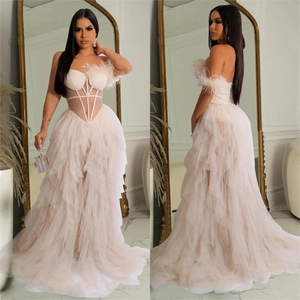 Detail of cream white strapless tulle gown with feather accents and corset boning