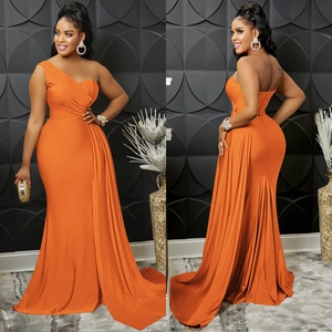 Detail of a bright orange one-shoulder evening dress with ruffles and a mermaid train