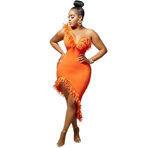Detail view of orange one-shoulder dress featuring premium feather trim and asymmetric hemline