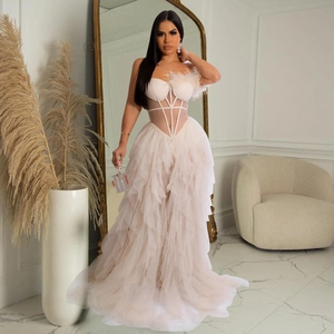 Detail of elegant cream strapless mesh maxi dress with ruffled skirt and feather shoulder accent