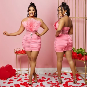 Pink strapless ruched dress featuring ostrich feather trim and rhinestone accents