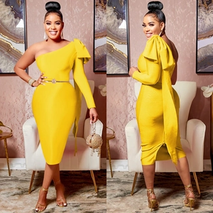 Detail of elegant one shoulder yellow bodycon dress featuring a large bow and slim fit