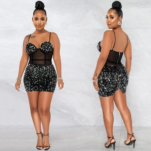 Détail d'une robe courte noire à paillettes avec taille en mesh et fines bretelles