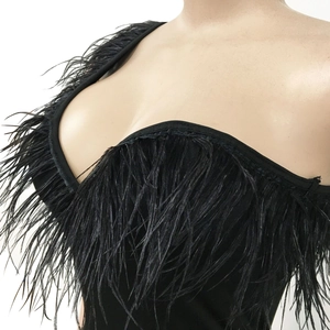 Detail shot of black strapless evening dress featuring luxurious feather trim along neckline