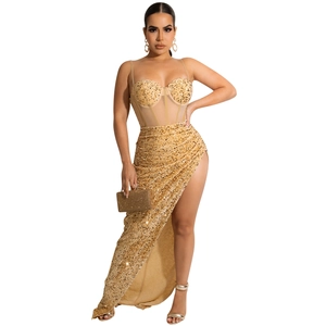 Detail of gold sequin evening dress with sheer corset top and high slit skirt