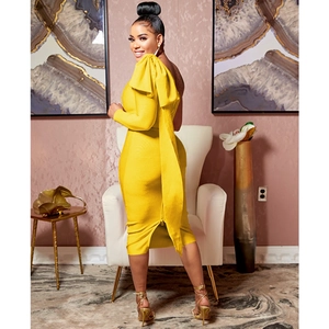 Detail of one-shoulder yellow midi dress featuring a dramatic large bow decoration