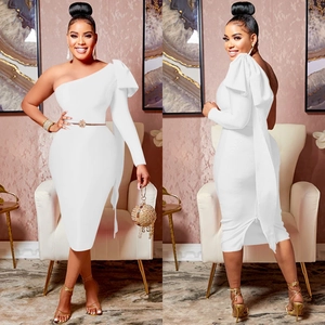 Detail of white one-shoulder midi dress featuring a large ruffle and floral metal belt
