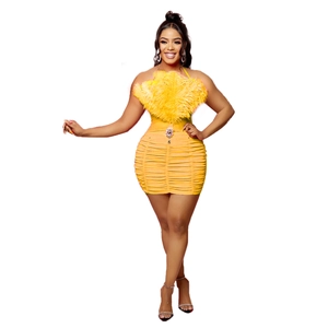 Detail of yellow ruched party dress featuring feather trim and a rhinestone waist buckle