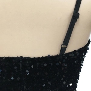 Detail of black sequined dress showing adjustable spaghetti straps and reflective fabric