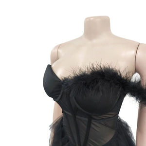 Detail of black strapless dress featuring feathered neckline and sheer mesh corset bodice