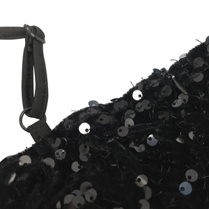 Detail of adjustable black strap and shimmering sequins on a mesh party dress