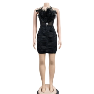 Detail of elegant black dress showing luxe feather trim and ruched fabric texture