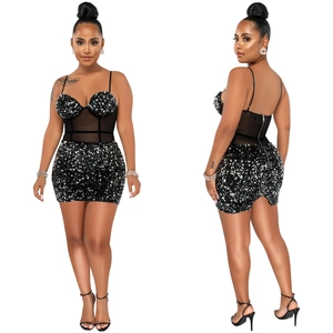 Détail macro d'une robe courte noire à paillettes avec taille en mesh et fermeture éclair dos
