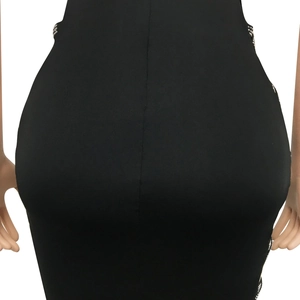 Détail d'une robe moulante noire avec strass argentés et fente latérale sexy