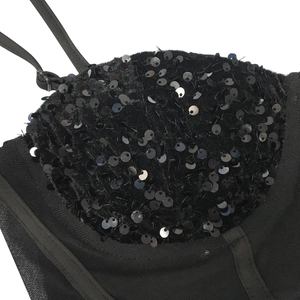Close-up of black sequins on mesh fabric and adjustable straps of a corset dress