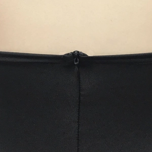 Détail de la fermeture éclair invisible sur une robe noire élégante en tissu sergé