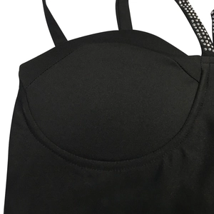 Détail de la robe noire à encolure cœur avec une bretelle ornée de strass scintillants